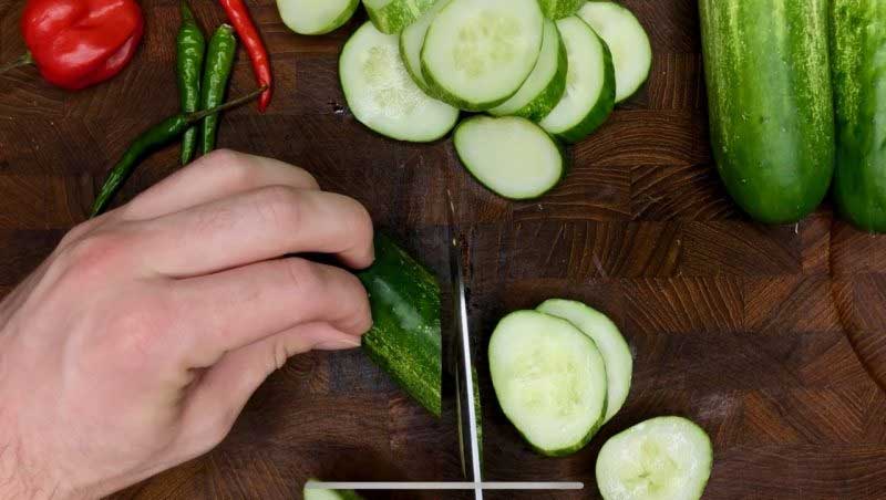 Slicing cucumbers on cutting board