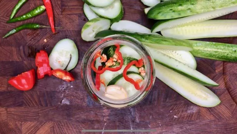 Sliced cucumbers and peppers in jar