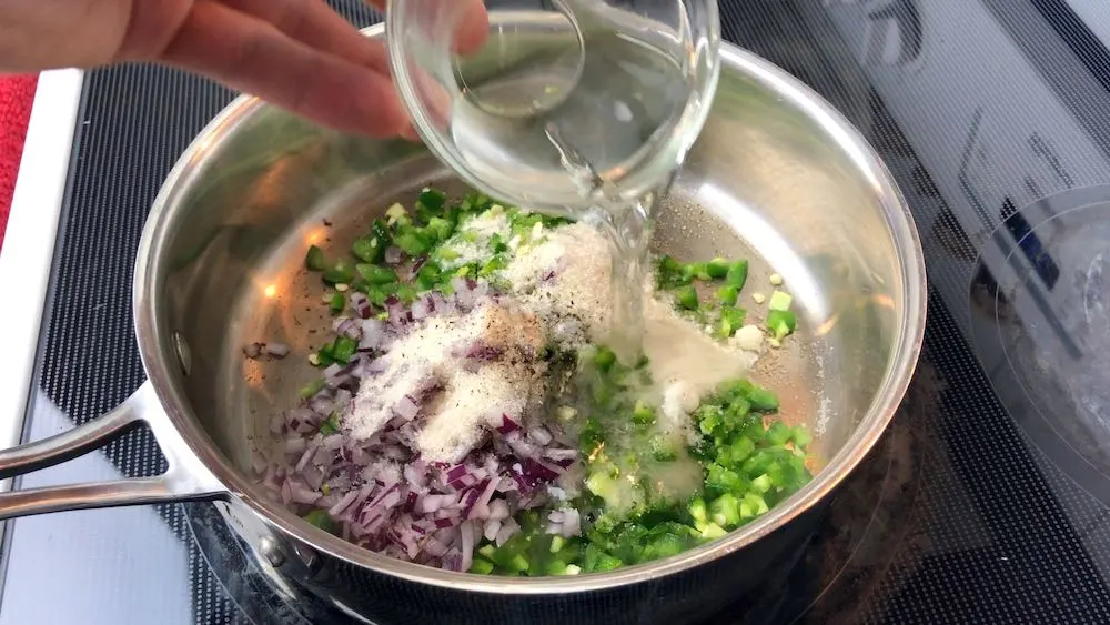 Adding spicy relish ingredients to pan
