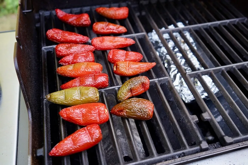 Red jalapenos smoking on the grill