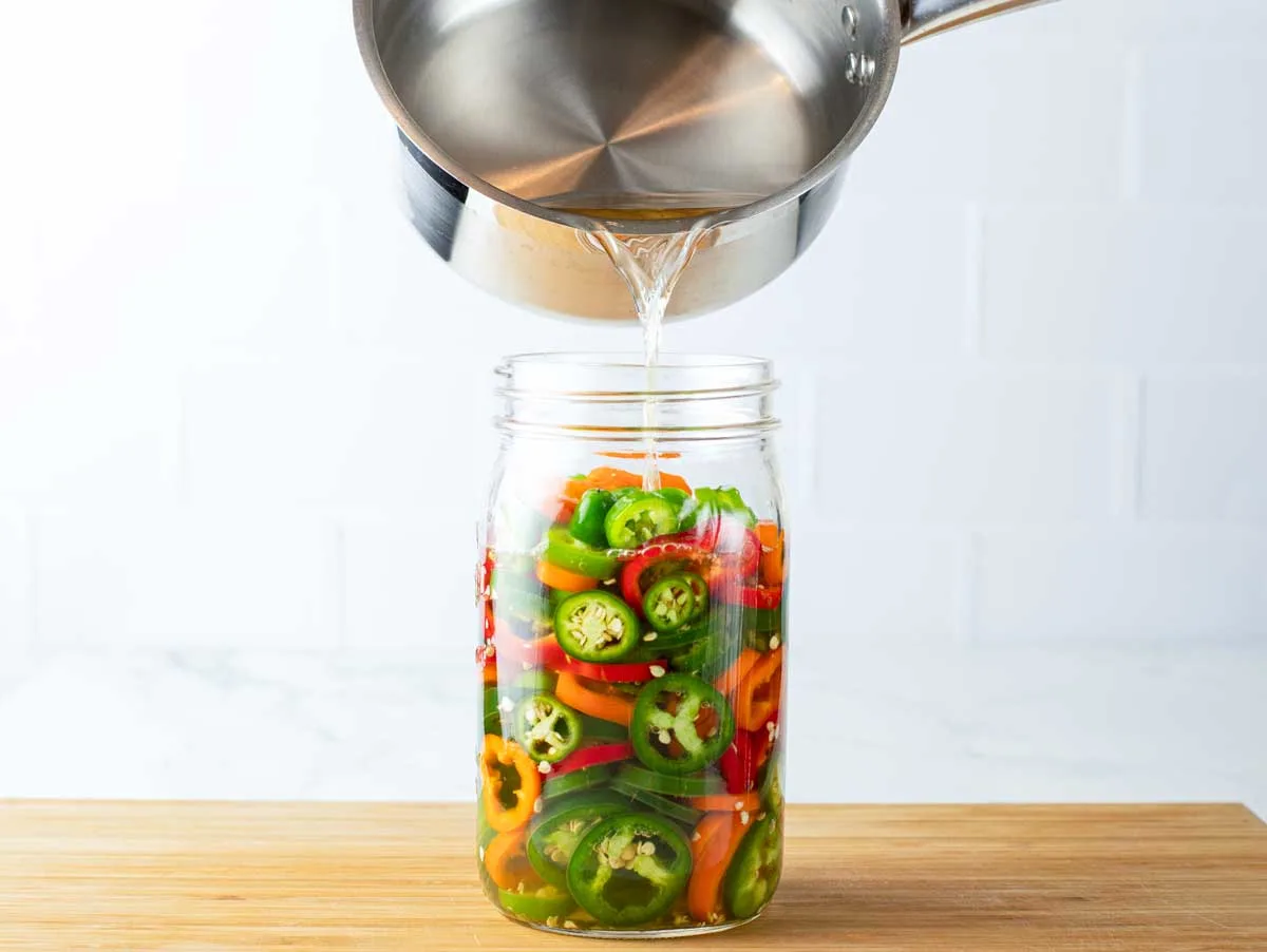Pouring brine over peppers