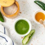 Overhead shot of jalapeno hot sauce in a serving bowl with honey and fresh peppers
