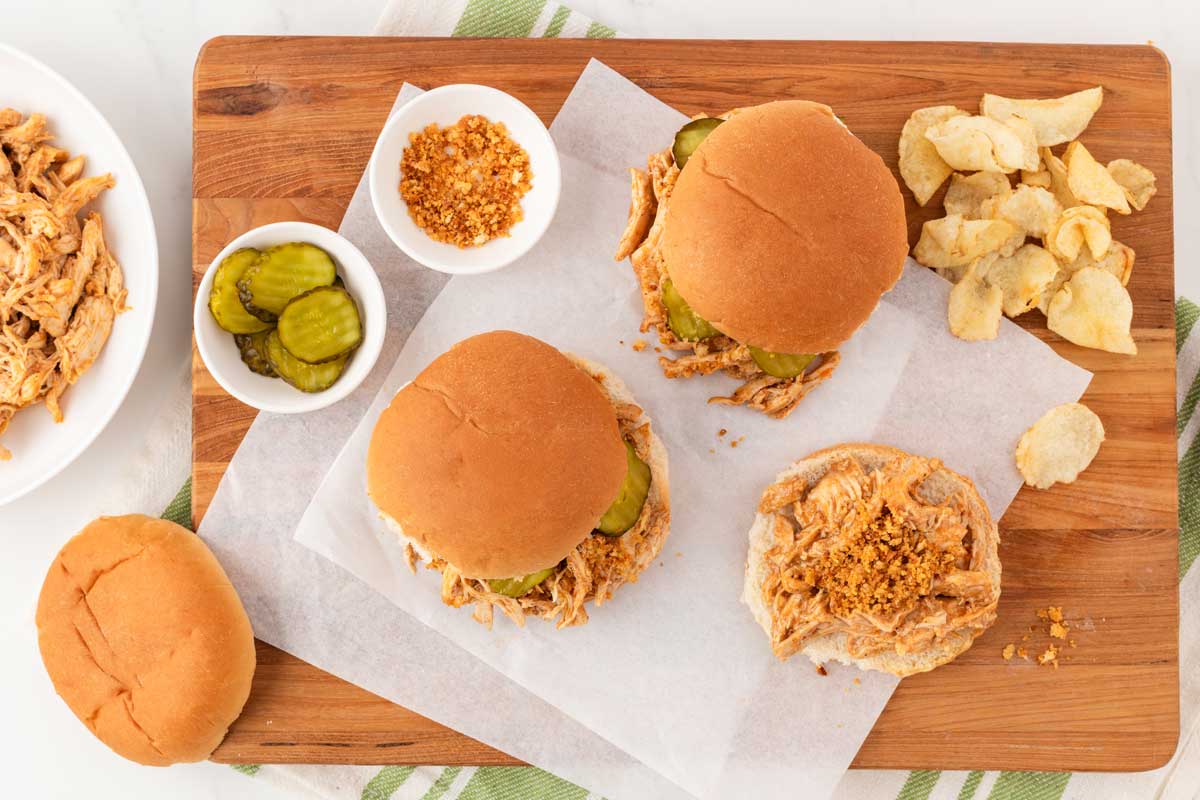 overhead shot of spicy nashville chicken sandwiches surrounded by toppings