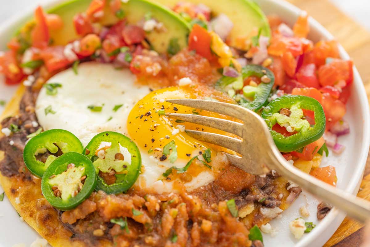 Side shot of fork digging into egg