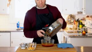 Pouring hot oil over dried chilies