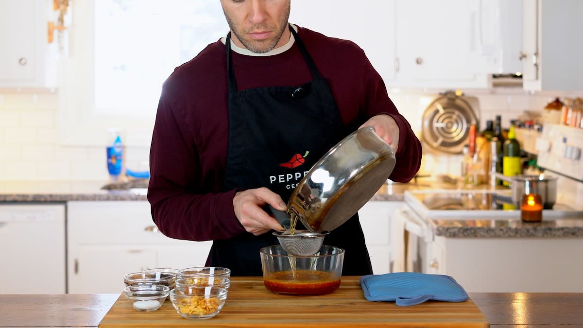 Pouring hot oil over dried chilies